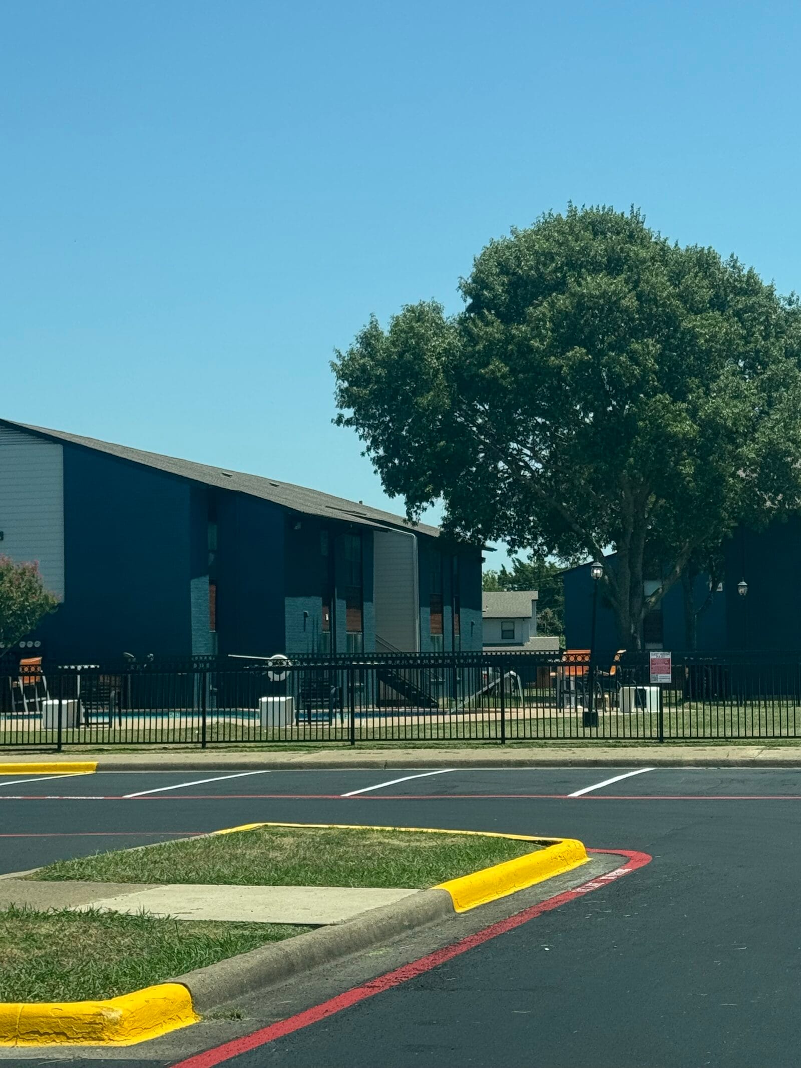 Seal coated lot with freshly painted yellow curb islands and red no-parking striping, Cedar Hill TX
