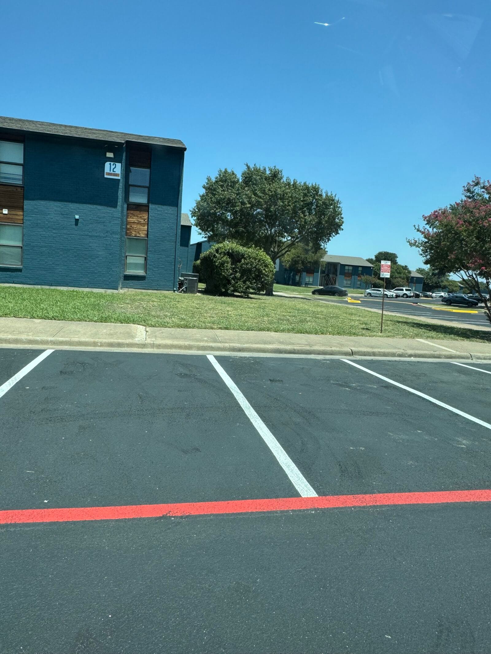 Repainted white parking stalls and red fire-lane striping on fresh sealcoat, Cedar Hill TX