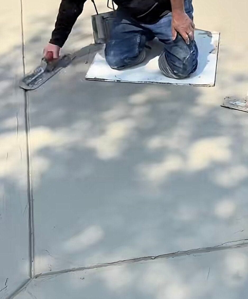 Hand troweling a smooth finish into the new concrete driveway extension slab in Venus TX