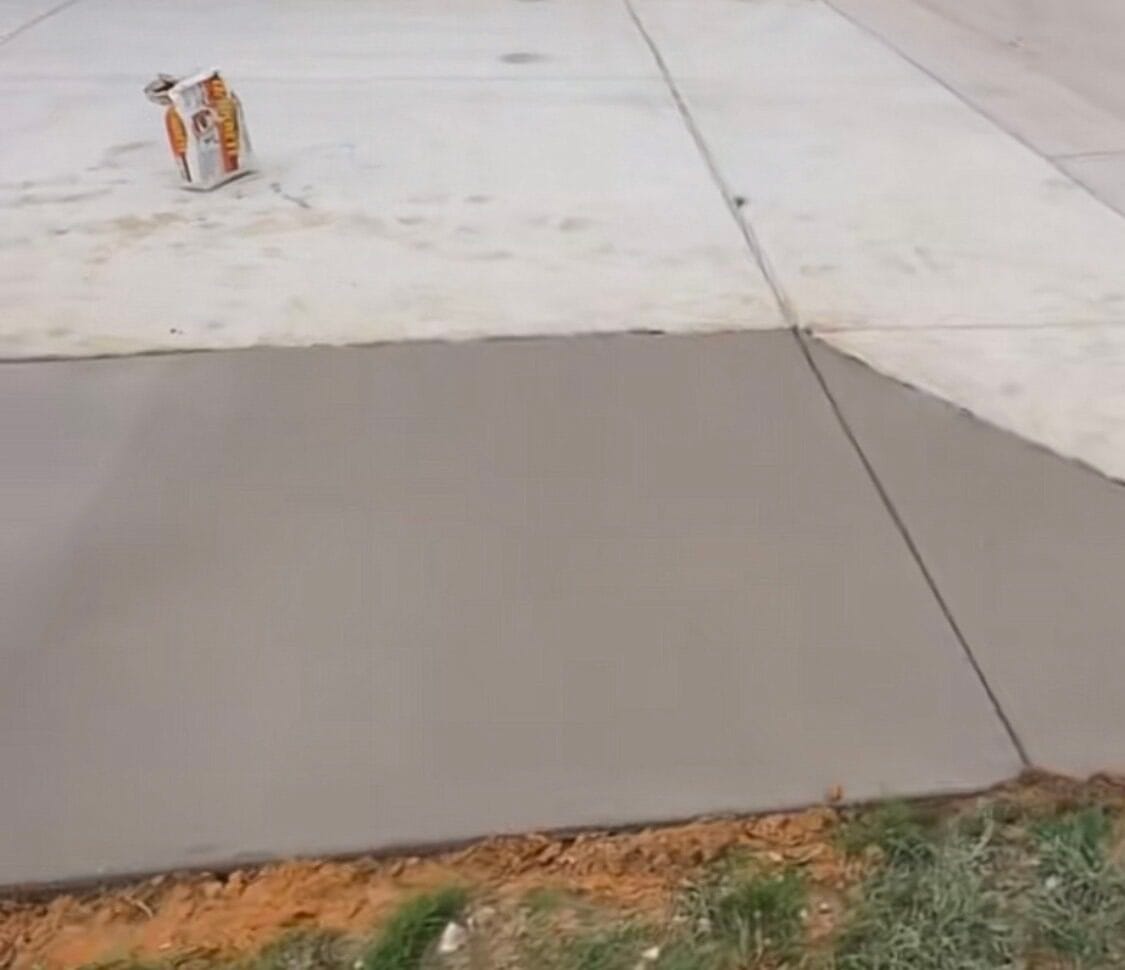 Finished concrete driveway extension with a clean control joint tying into the original slab, Waxahachie TX