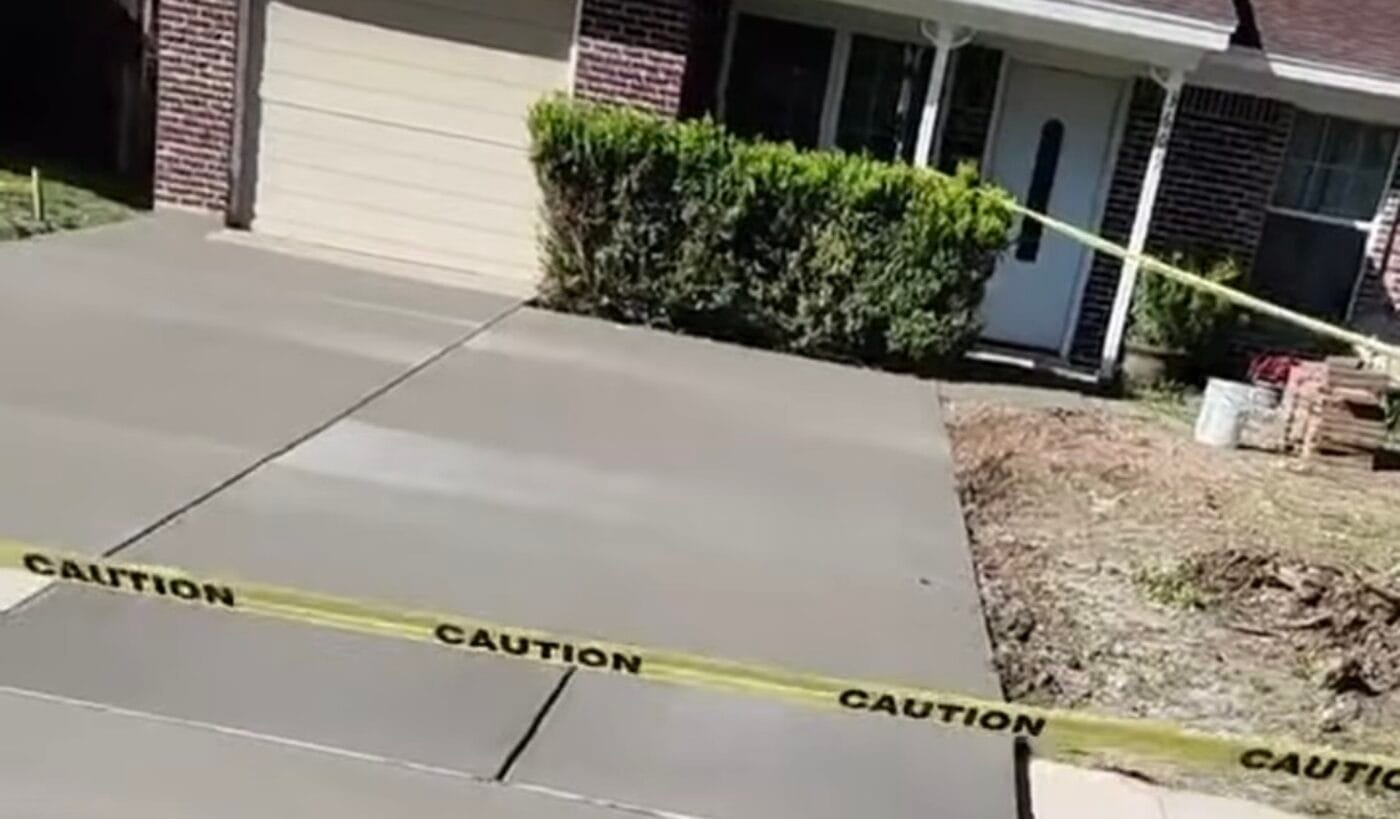 Fresh concrete driveway and walkway pour taped off to cure at a North Texas home
