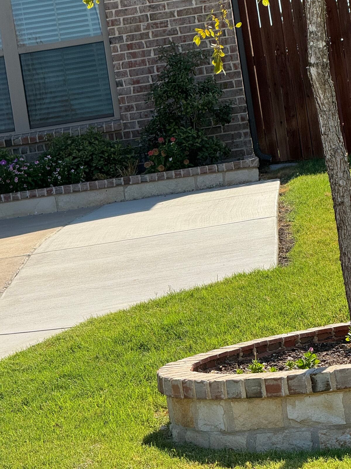 New concrete driveway extension with a broom finish and rolled edge alongside the flower bed, Glenn Heights TX