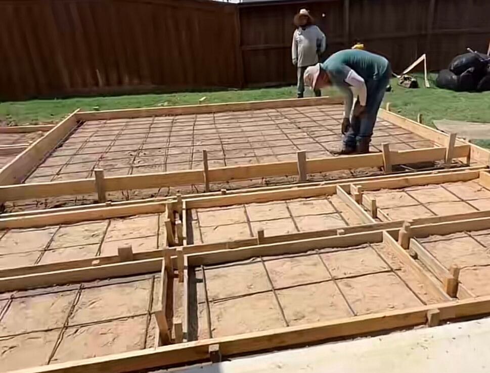 Wood forms and rebar grid set on a compacted sand base for a concrete patio and pad walkway in DeSoto TX