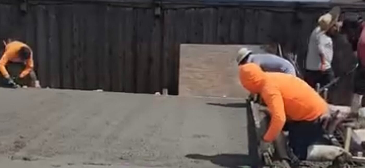 Concrete crew bull floating a fresh slab pour in Dallas TX