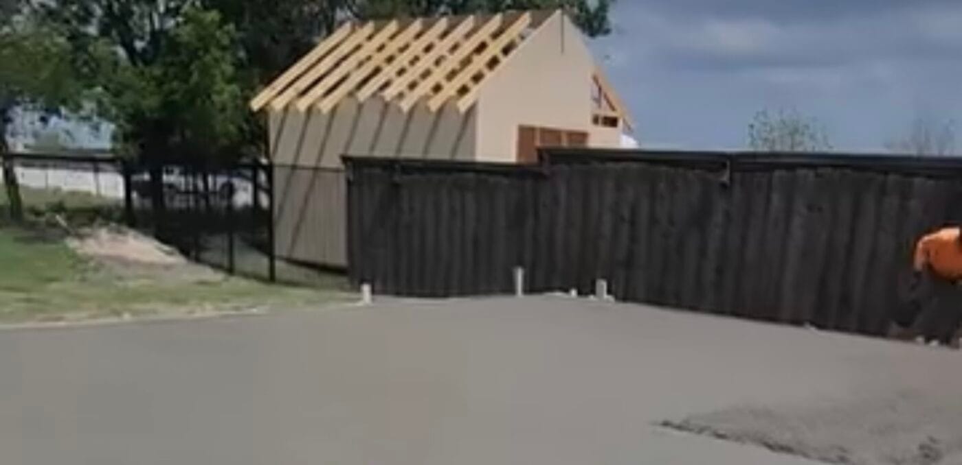 Smooth finished concrete slab along the fence line on a Dallas TX install